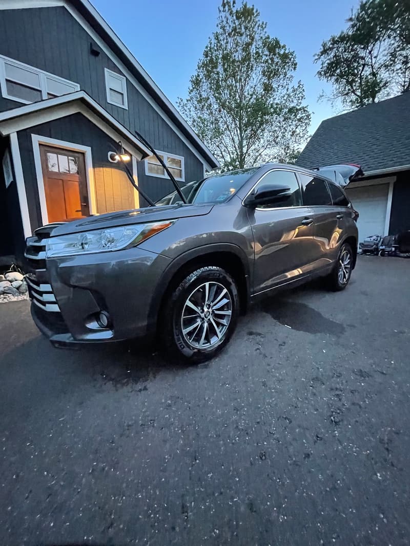Gray Toyota SUV with glossy paint and clean wheels in front of a home