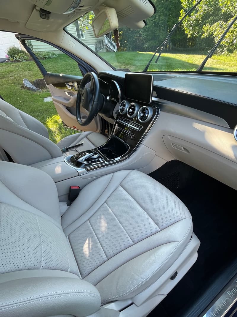 White leather front seats and dashboard of a Mercedes-Benz, cleaned and conditioned