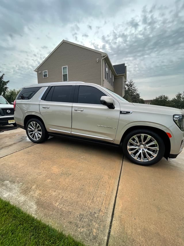 White full-size SUV gleaming in a customer's driveway