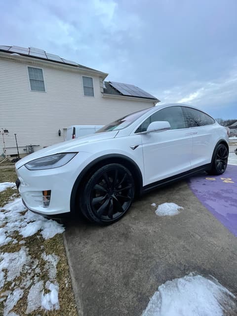 White Tesla Model X with a deep gloss finish after detailing, parked on a winter driveway